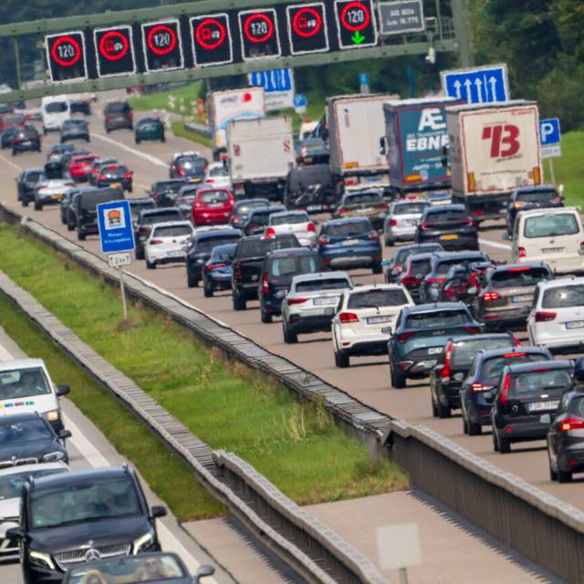 PKW und LKW stauen sich während des Rückreiseverkehr auf der Autobahnen A8 bei Holzkirchen.