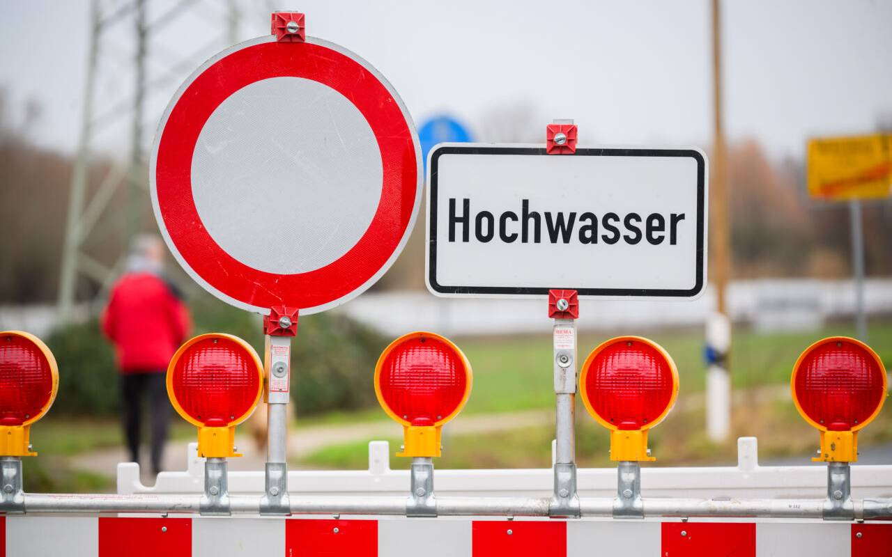 Ein Warnschild "Hochwasser" steht an einer Straßensperre an der Leinemasch in der südlichen Region Hannover.