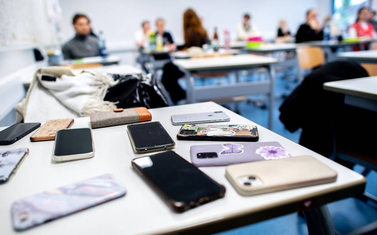 Zahlreiche Smartphones der Schülerinnen und Schüler liegen vor Beginn der schriftlichen Abiturprüfungen auf einem Tisch