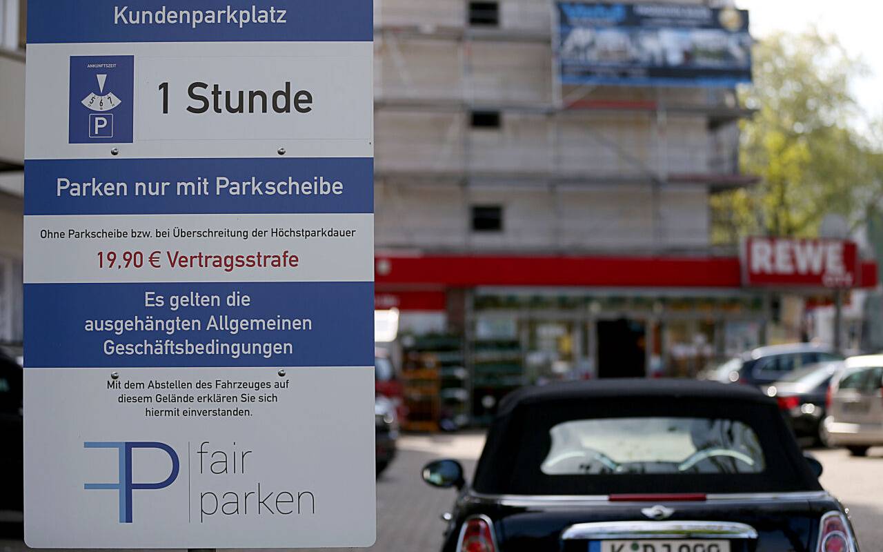 Ein Hinweisschild auf einem Parkplatz zwecks Gebühren ist zu erkennen.