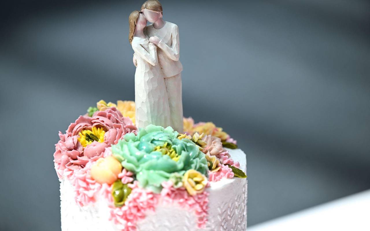 Die Figur eines Brautpaares steht auf einer Hochzeitstorte
