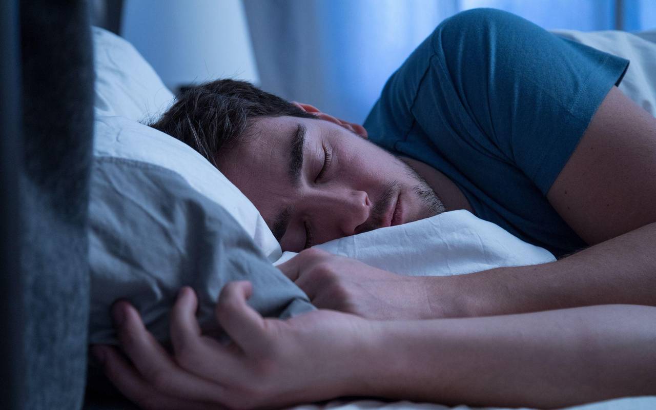 Mann schläft in einem Bett