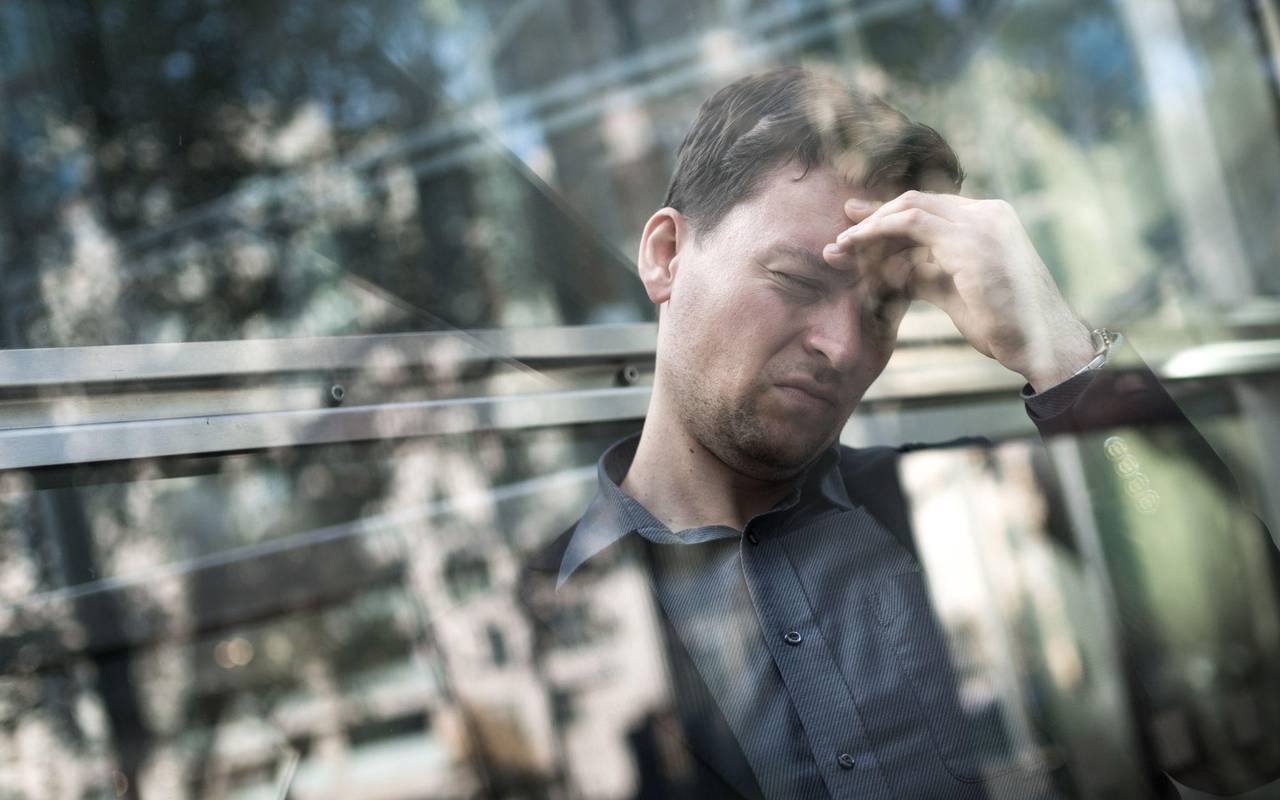 Gestresster Mann greift sich an die Stirn