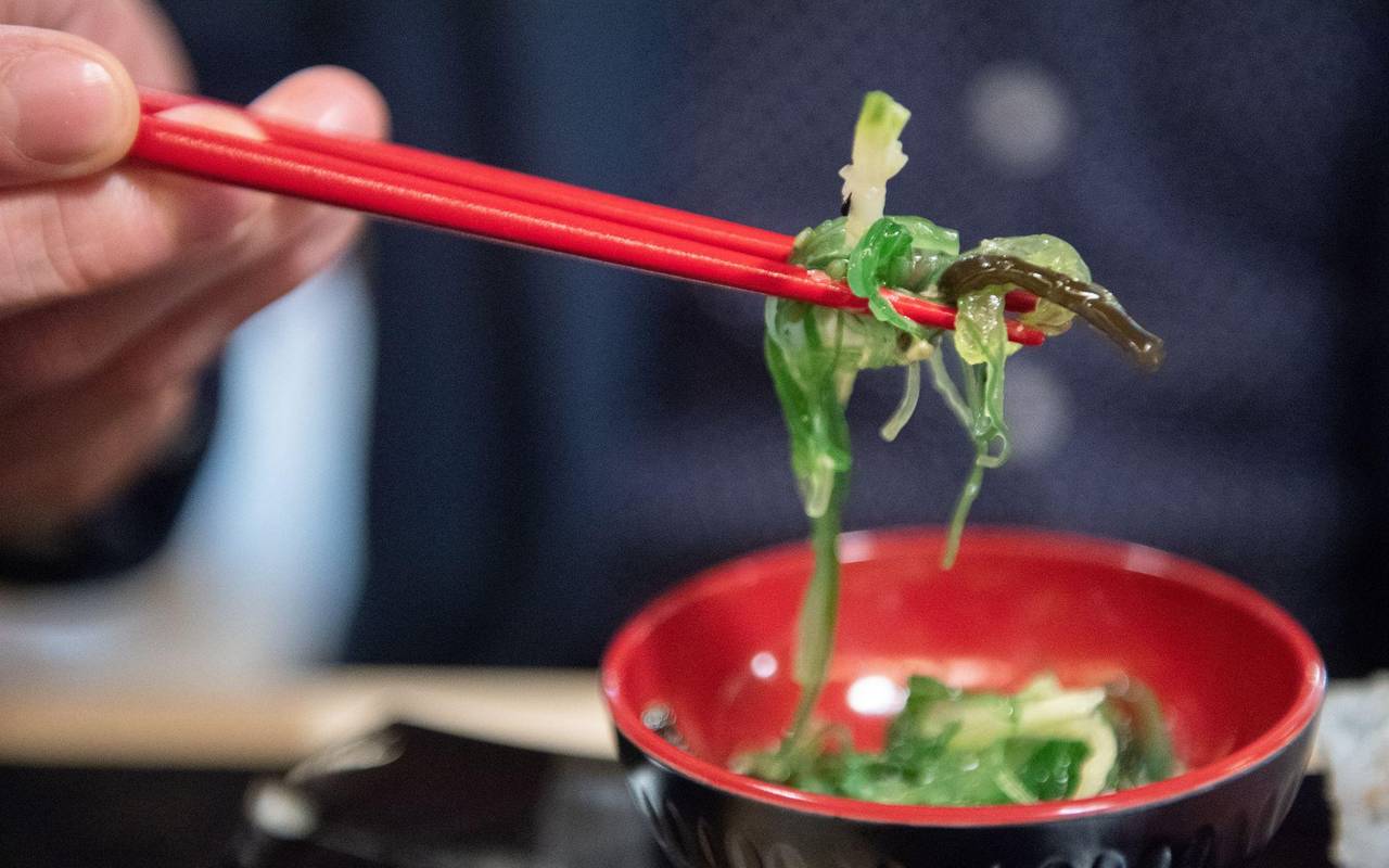 Ein Mann isst einen Wakame-Algensalat