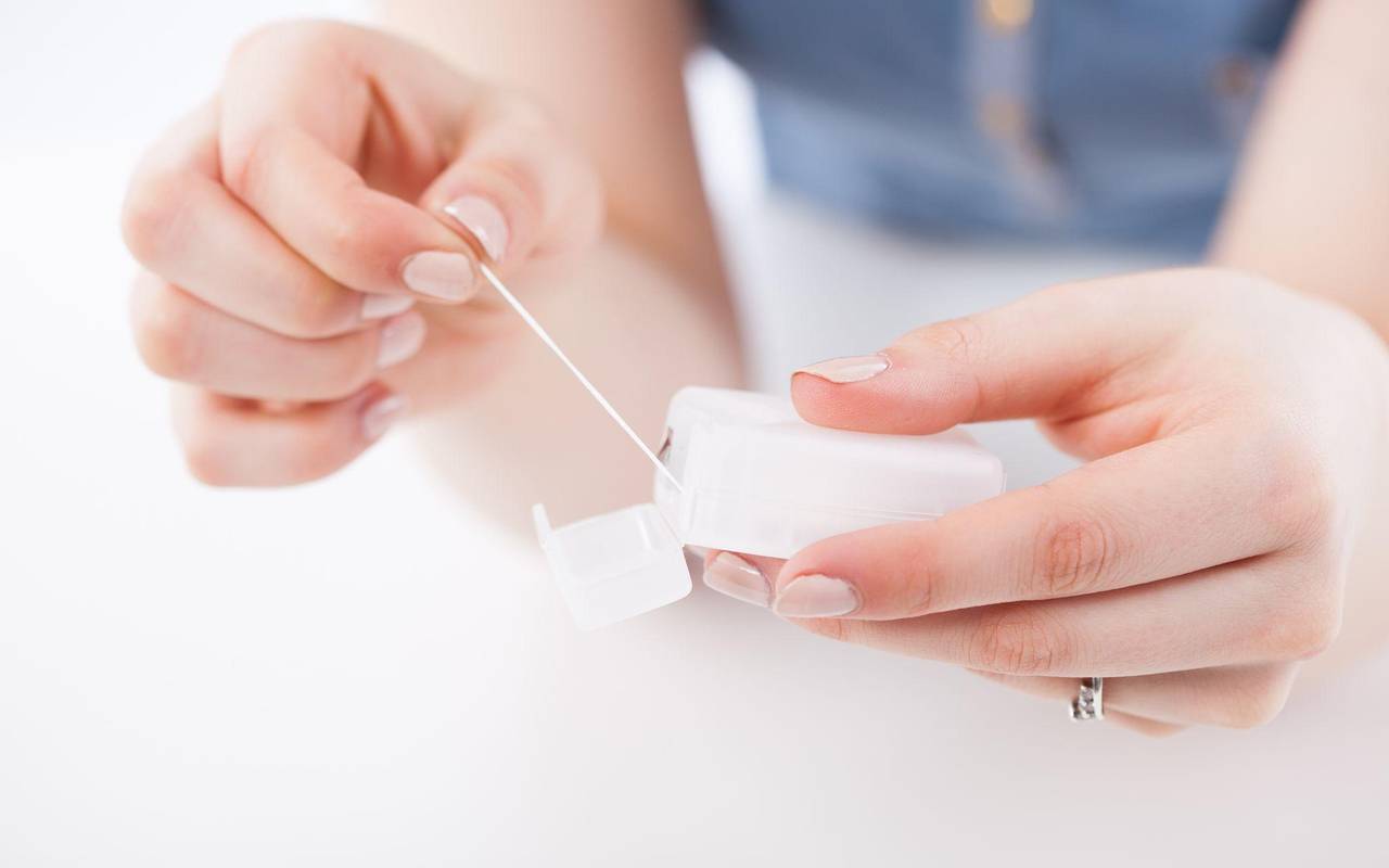 Eine Frau benutzt Zahnseide