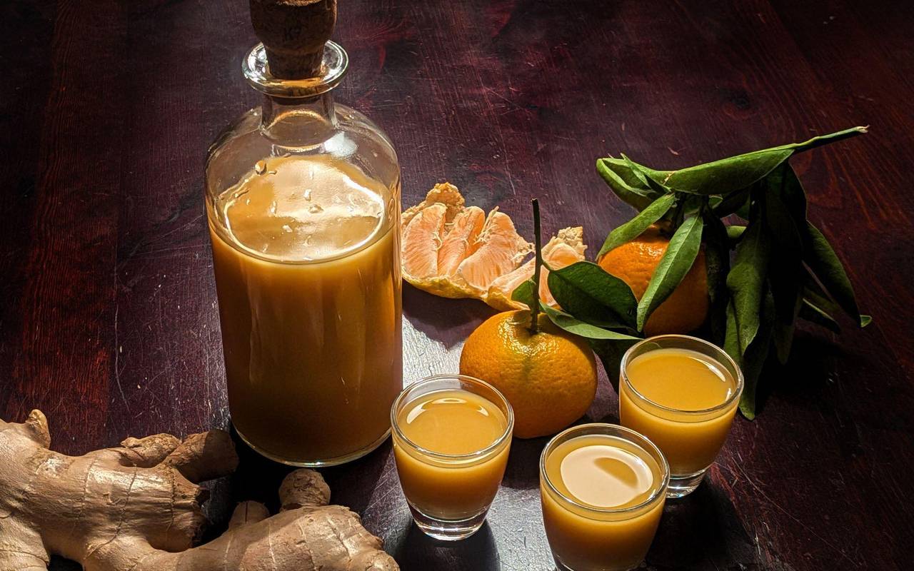 Eine Flasche und drei Gläser mit Ingwershot stehen auf dem Tisch