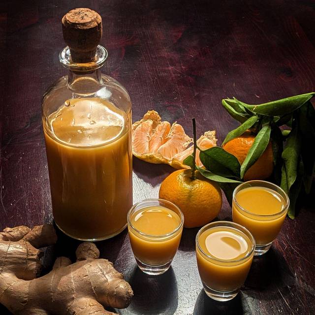 Eine Flasche und drei Gläser mit Ingwershot stehen auf dem Tisch