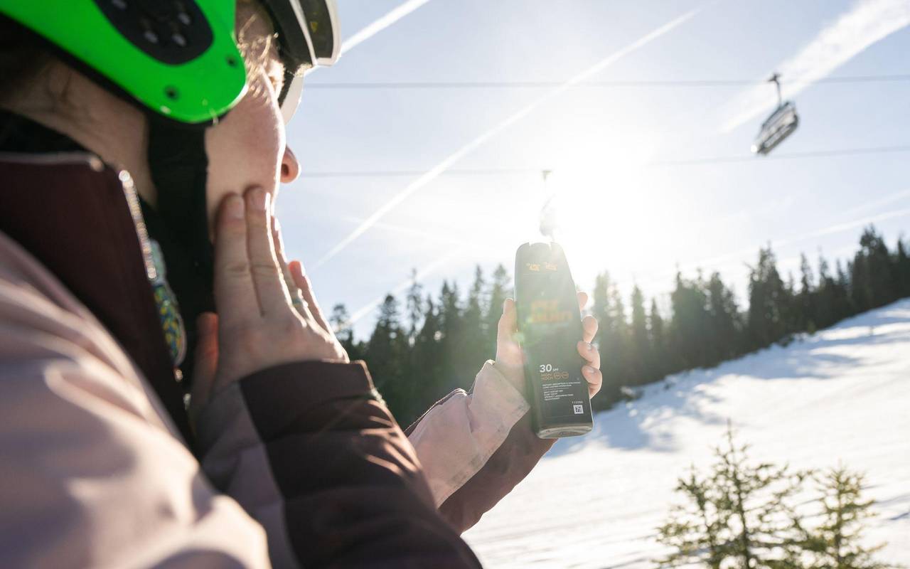 Eine Skifahrerin trägt Sonnencreme auf