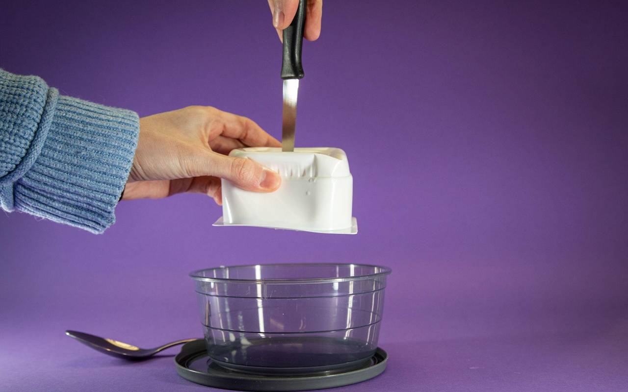 Quarkpackung wird mit einem Messer von oben eingestochen