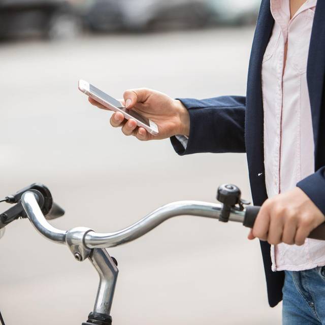 Eine Frau mit Smartphone und Fahrrad