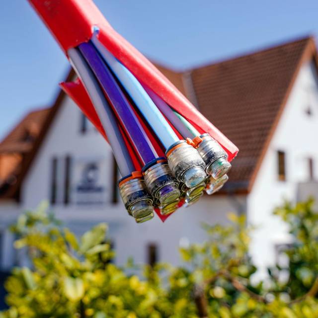 Bündel mit Umhüllungen für Glasfaserkabel vor einem Wohnhaus