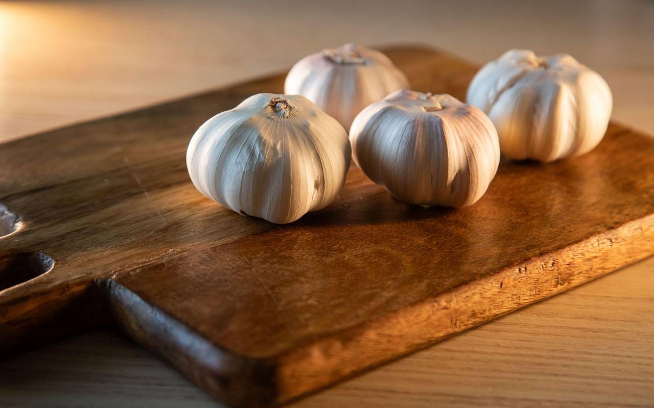 Knoblauchknollen liegen auf einem Küchentisch