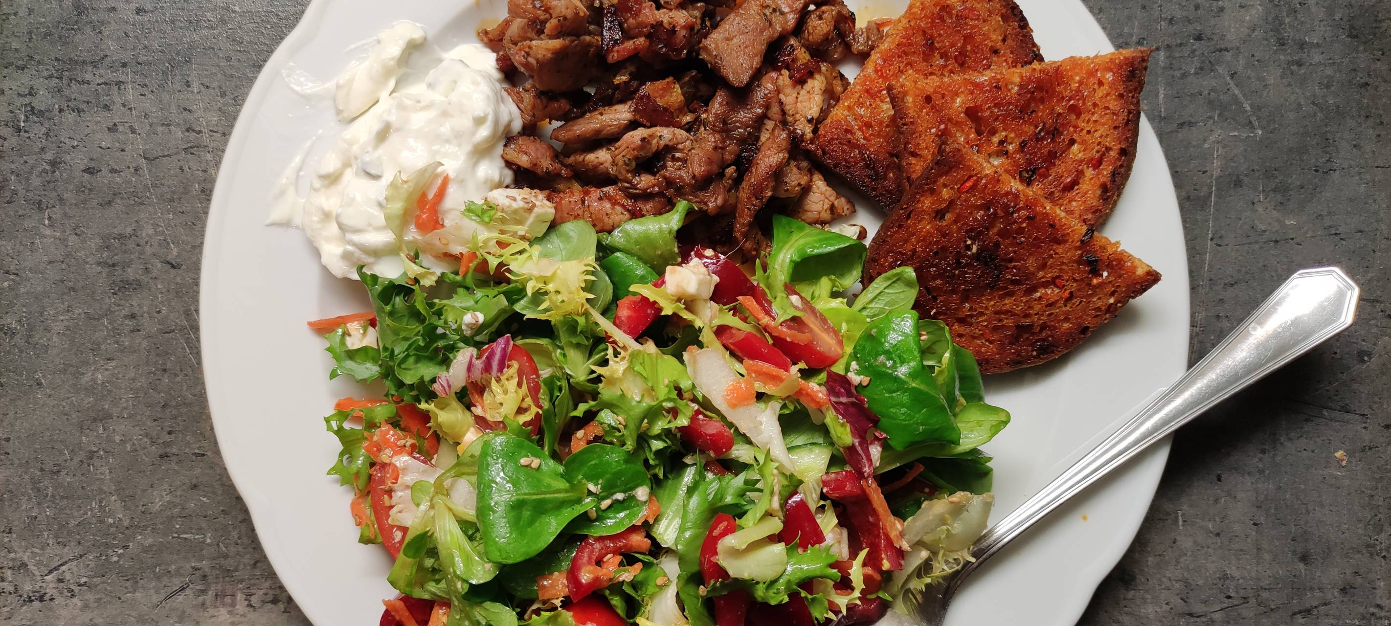 Selbstgewürztes Hähnchengyros mit Salat, Zaziki und geröstetem Karottenbrot