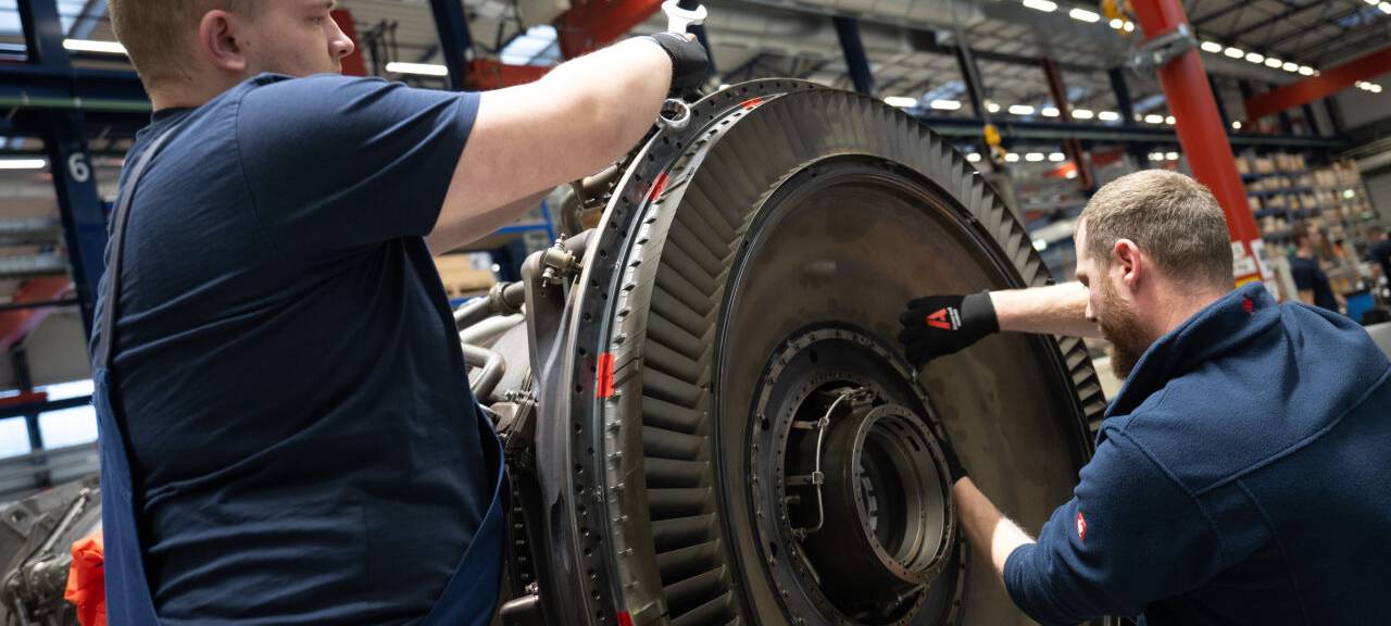 Mitarbeiter arbeiten bei MTU Maintenance Berlin-Brandenburg an einem Antrieb,