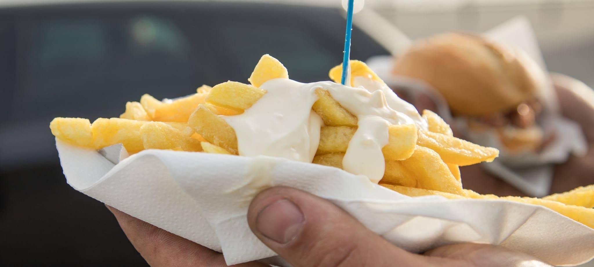 Person hält Pommes mit Mayo
